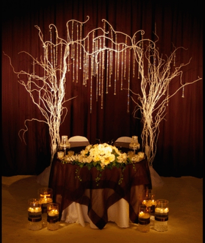 Whimsical tree branches, crystals and lighting create a fabulous setting for a sweet heart table Image provided by The Finishing Touch Event Design